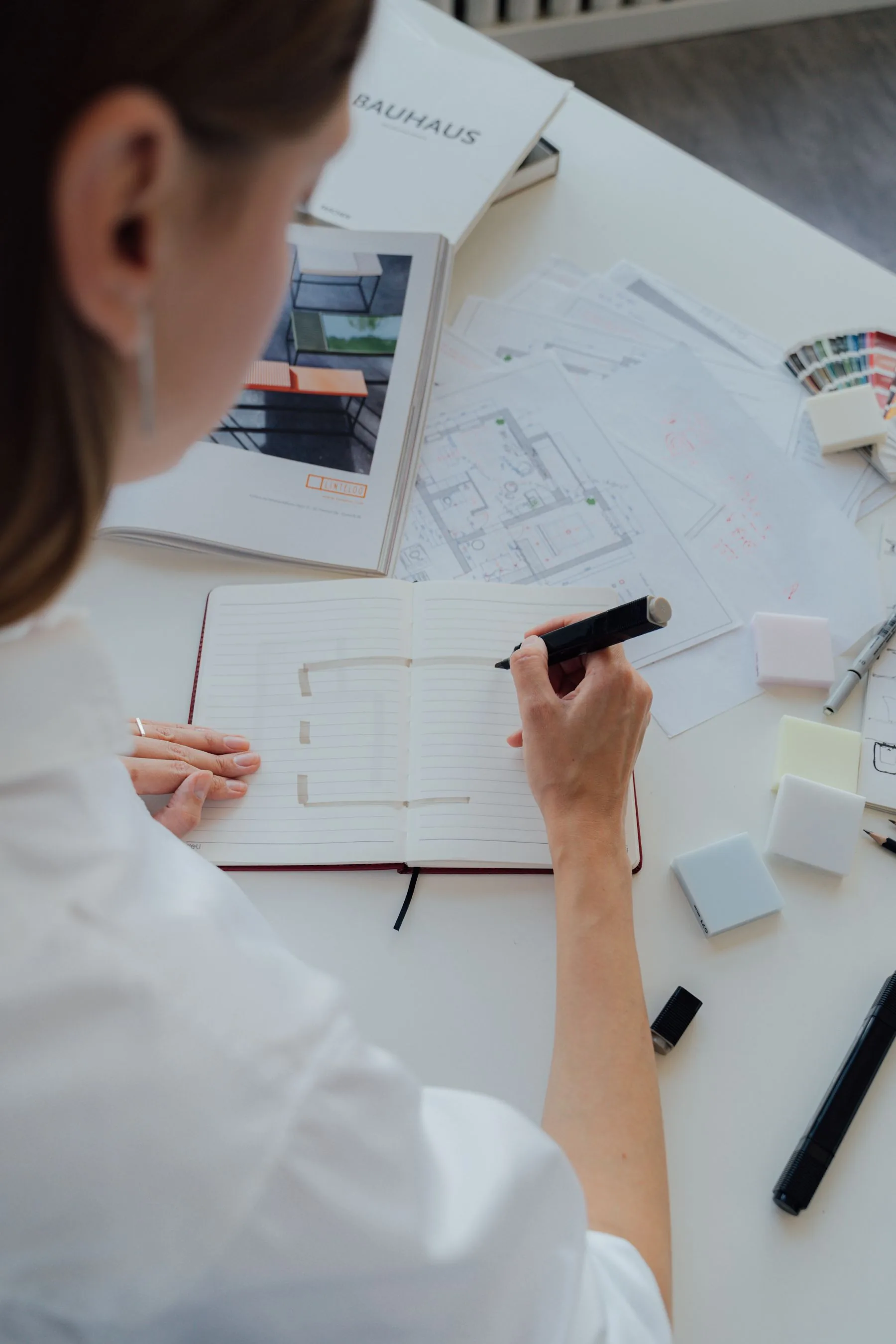 Planungsskizzen und Materialmuster auf einem Schreibtisch